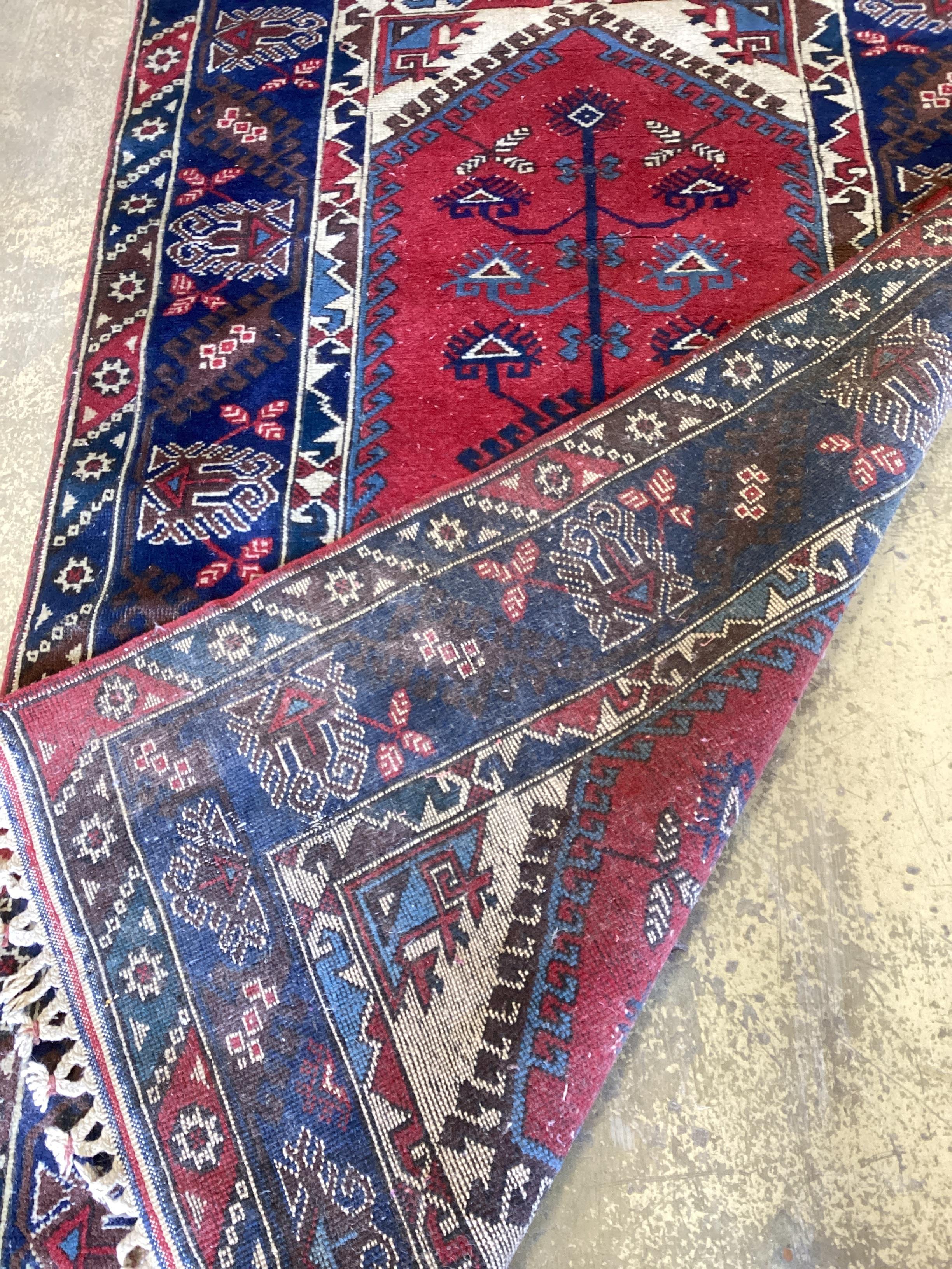 A Caucasian style red ground rug, 205 x 124cm